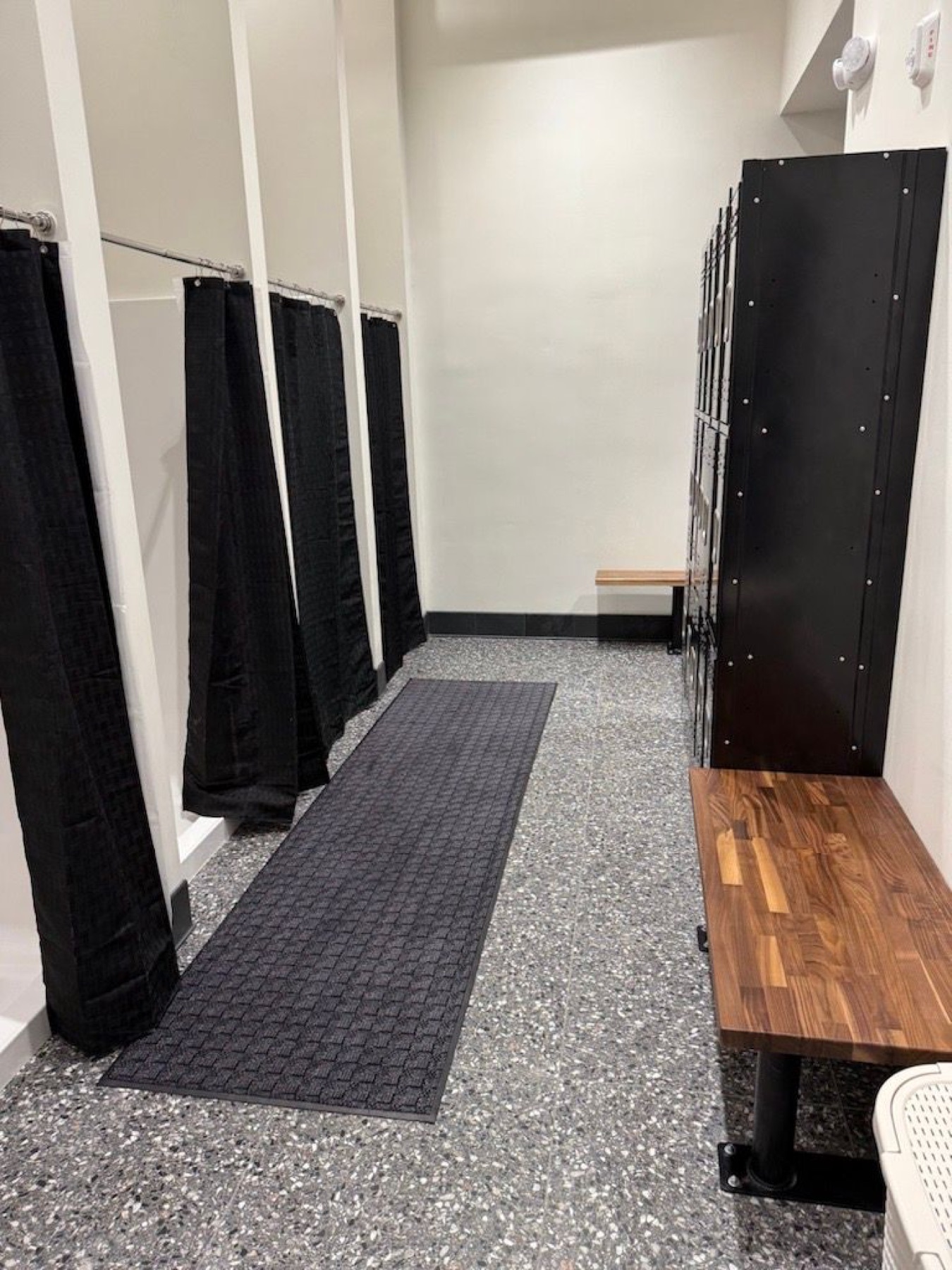 Black lockers and bench inside the Downtown changing room